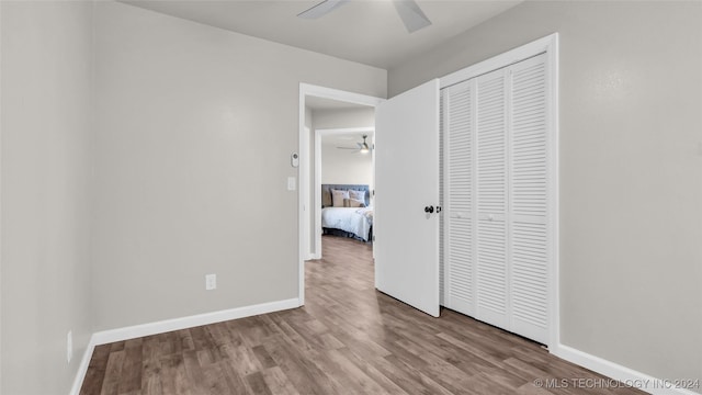 unfurnished bedroom featuring wood-type flooring, a closet, and ceiling fan