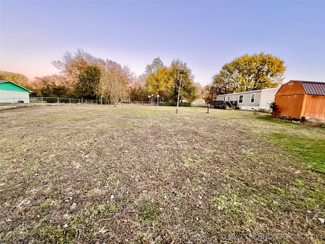 yard at dusk featuring an outbuilding