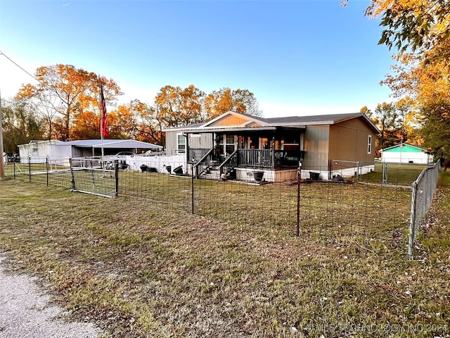 back of property featuring covered porch and a yard