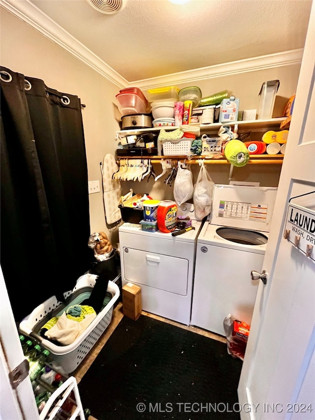 clothes washing area featuring a textured ceiling, washer and clothes dryer, and ornamental molding