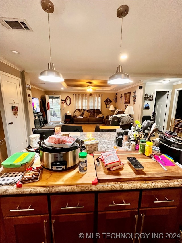 kitchen featuring hanging light fixtures and crown molding