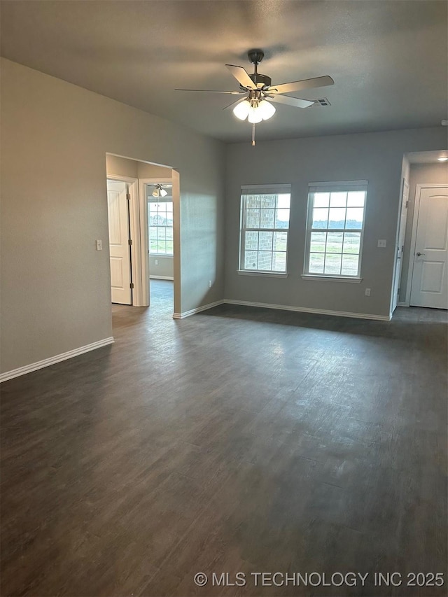 empty room featuring dark wood-type flooring and ceiling fan