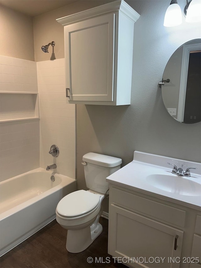 full bathroom featuring vanity, hardwood / wood-style floors, shower / bathtub combination, and toilet