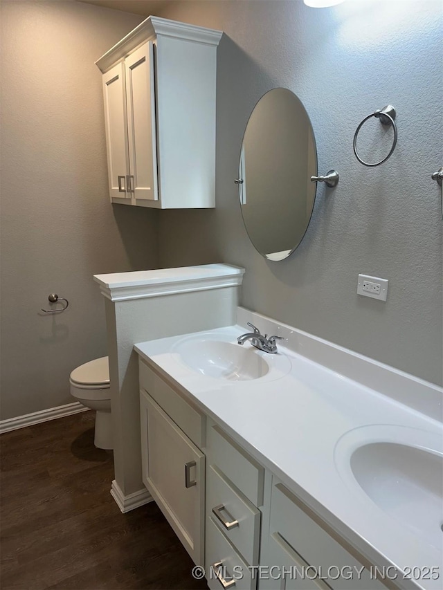 bathroom featuring wood-type flooring, toilet, and vanity