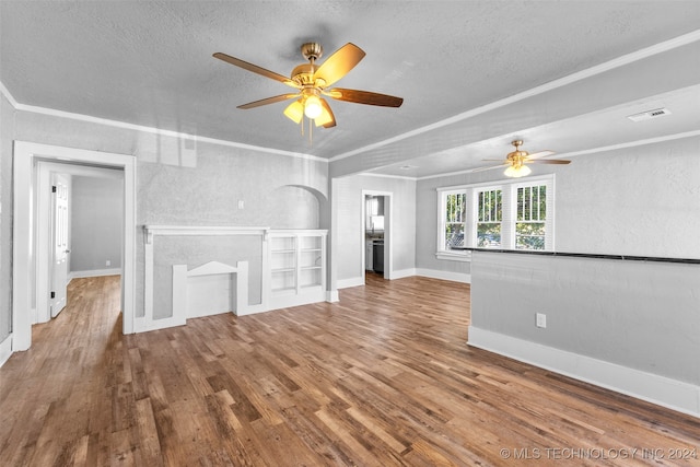 unfurnished living room featuring hardwood / wood-style flooring, ornamental molding, and a textured ceiling