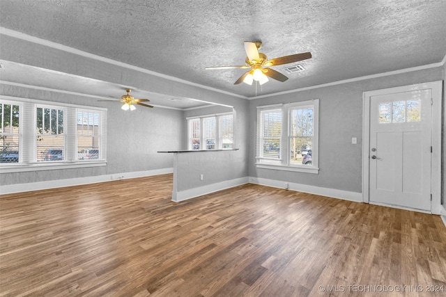 unfurnished living room with a textured ceiling, hardwood / wood-style floors, and plenty of natural light