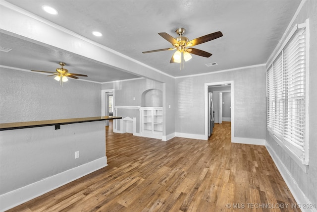 unfurnished living room featuring wood-type flooring, ceiling fan, and crown molding