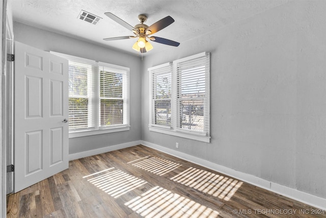 spare room with hardwood / wood-style floors, ceiling fan, and a healthy amount of sunlight