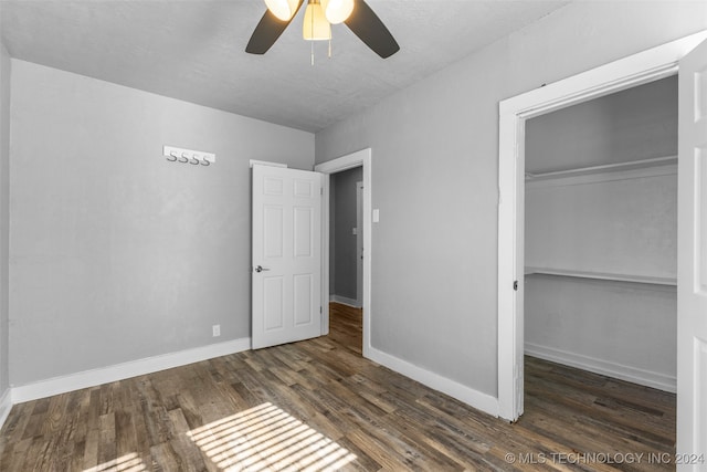 unfurnished bedroom featuring ceiling fan, a closet, and dark hardwood / wood-style floors