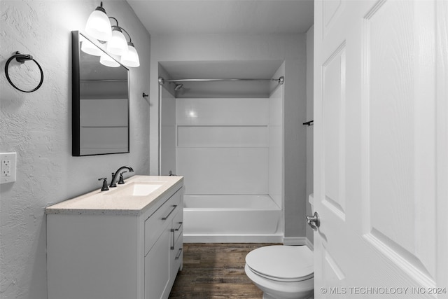 full bathroom with hardwood / wood-style floors, vanity, toilet, and shower / washtub combination