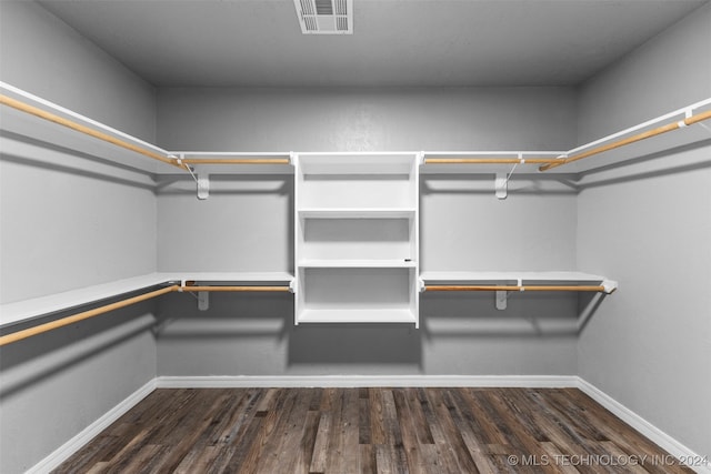 walk in closet with dark wood-type flooring