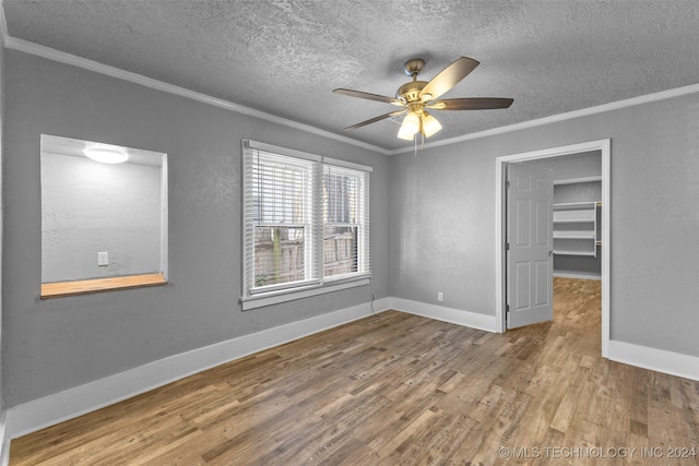 spare room featuring hardwood / wood-style flooring, ceiling fan, ornamental molding, and a textured ceiling