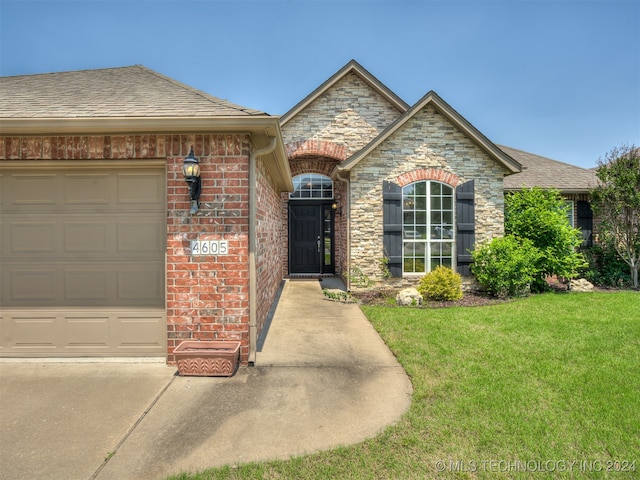 ranch-style house featuring a garage and a front lawn