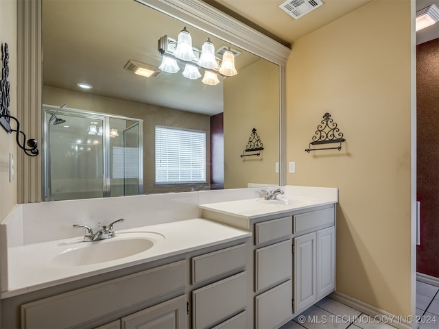 bathroom with tile patterned flooring, vanity, and walk in shower