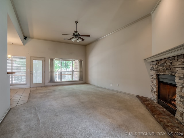 unfurnished living room with a fireplace, light colored carpet, ceiling fan, and ornamental molding