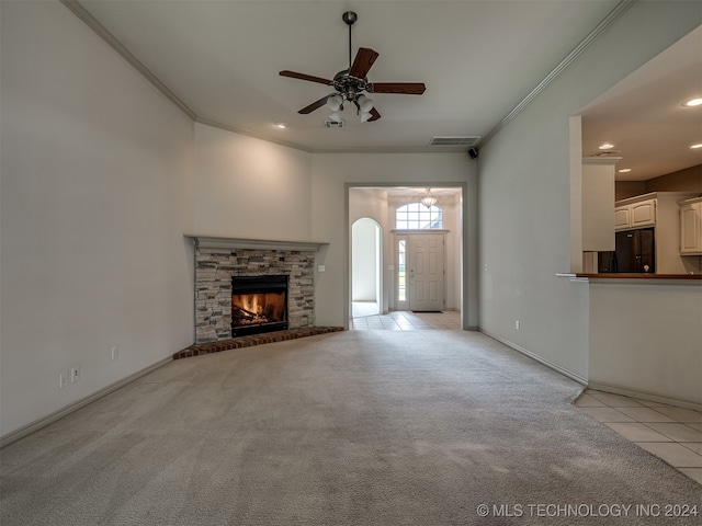 unfurnished living room featuring crown molding, a fireplace, light tile patterned flooring, and ceiling fan