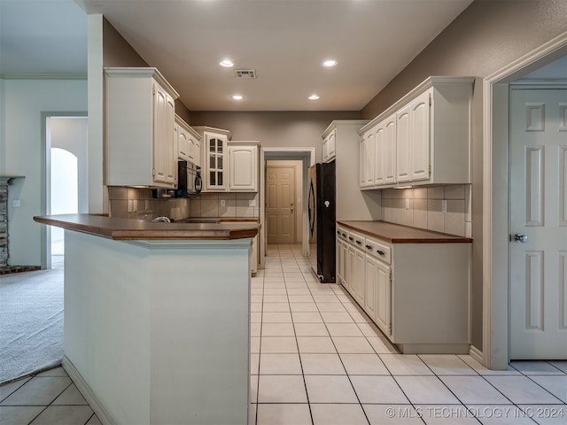 kitchen featuring backsplash, kitchen peninsula, white cabinetry, and black appliances