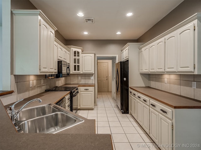 kitchen with white cabinetry, black appliances, and sink