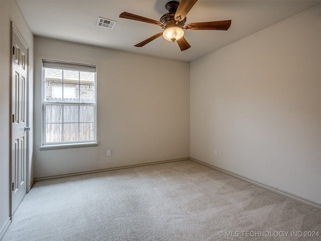 empty room featuring ceiling fan and light carpet