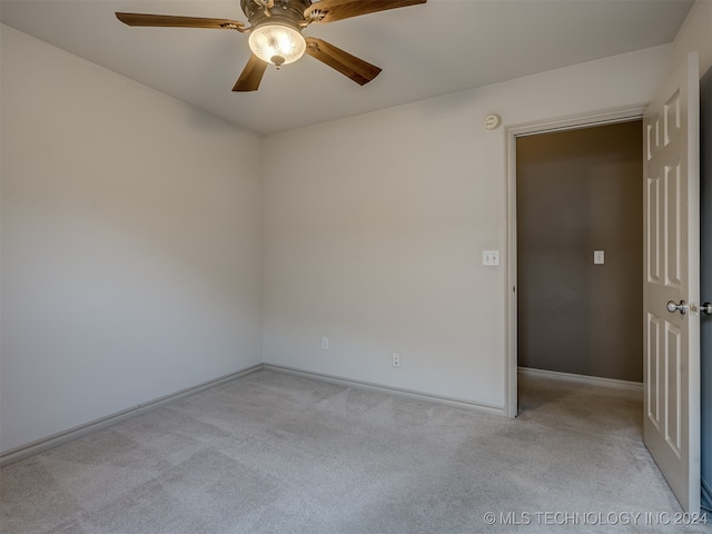 empty room featuring light colored carpet and ceiling fan