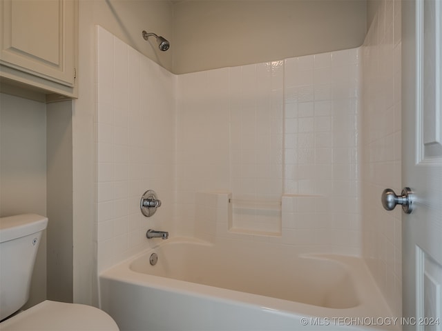 bathroom with tiled shower / bath combo and toilet