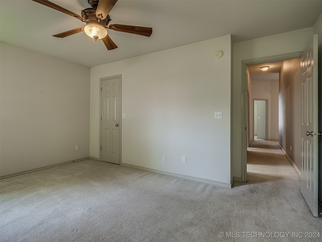 carpeted spare room featuring ceiling fan