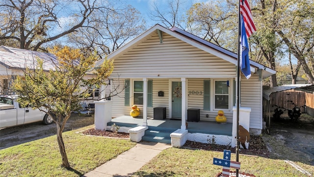 bungalow-style home with covered porch and a front yard