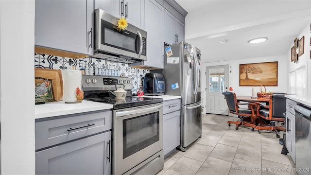 kitchen featuring gray cabinetry, a healthy amount of sunlight, and appliances with stainless steel finishes