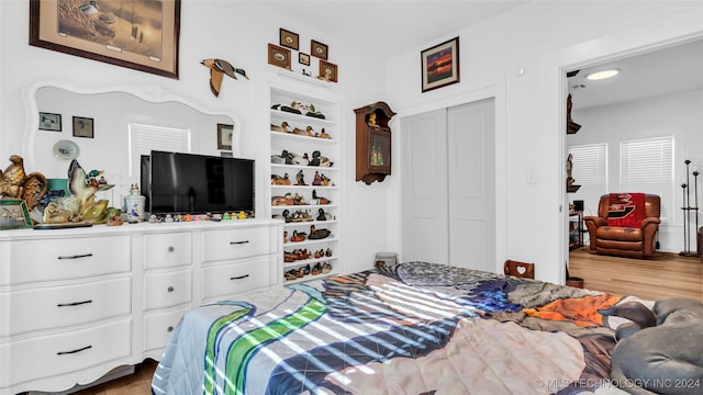 bedroom with light wood-type flooring and a closet