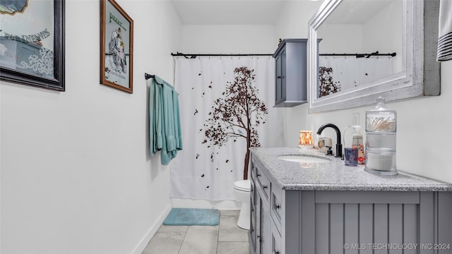 bathroom with tile patterned flooring, vanity, toilet, and walk in shower