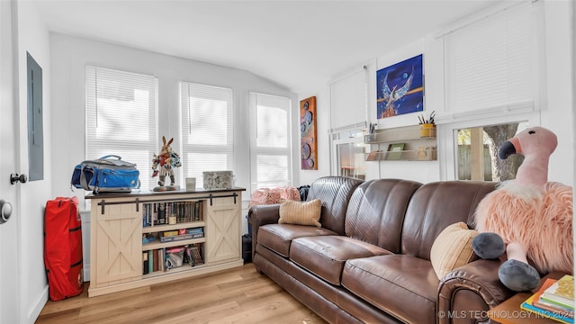 living room with electric panel, light hardwood / wood-style flooring, and lofted ceiling