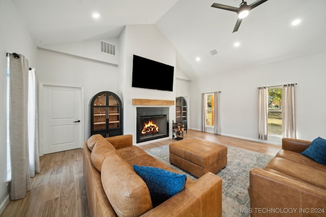 living room featuring ceiling fan, high vaulted ceiling, and light hardwood / wood-style floors