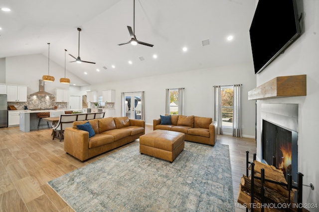 living room with light wood-type flooring and high vaulted ceiling