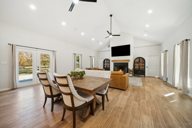 dining room featuring french doors, light wood-type flooring, high vaulted ceiling, and ceiling fan