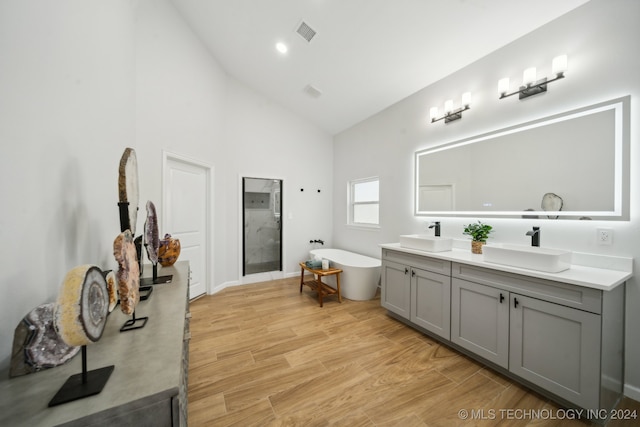 bathroom featuring hardwood / wood-style floors, vanity, high vaulted ceiling, and independent shower and bath