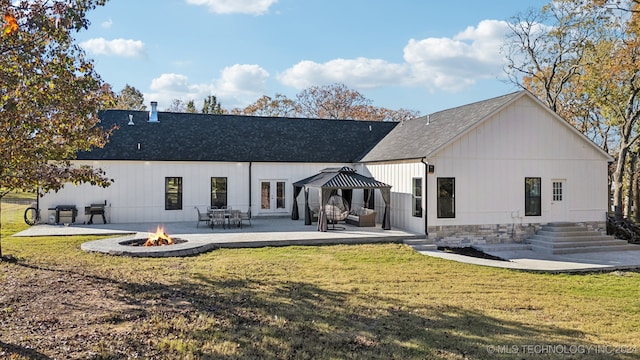 rear view of house with a yard, an outdoor fire pit, a patio, and french doors