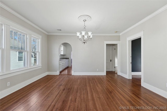 unfurnished dining area featuring dark hardwood / wood-style floors, crown molding, and a notable chandelier