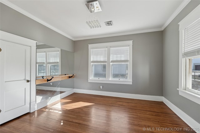 spare room featuring hardwood / wood-style flooring, a wealth of natural light, and crown molding