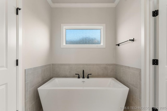 17537 S 56th E Ave, Bixby, OK 74008 - bathroom featuring a freestanding bath, tile walls, and ornamental molding
