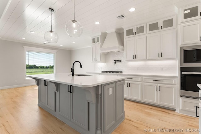 17537 S 56th E Ave, Bixby, OK 74008 - kitchen featuring a sink, custom range hood, light countertops, white cabinets, and a center island with sink