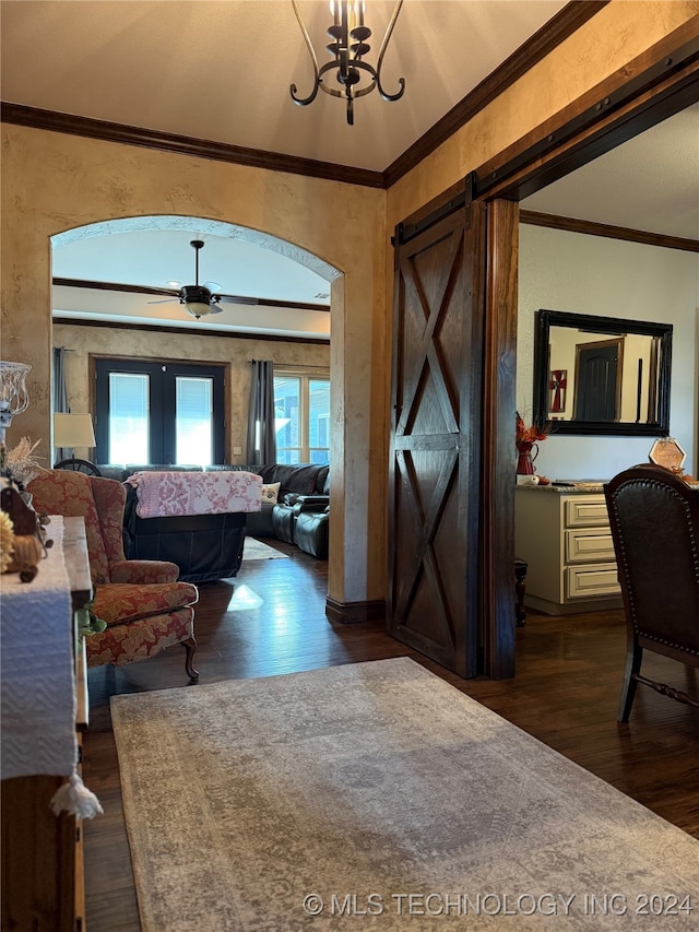 foyer entrance with french doors, dark hardwood / wood-style floors, a barn door, ceiling fan, and ornamental molding