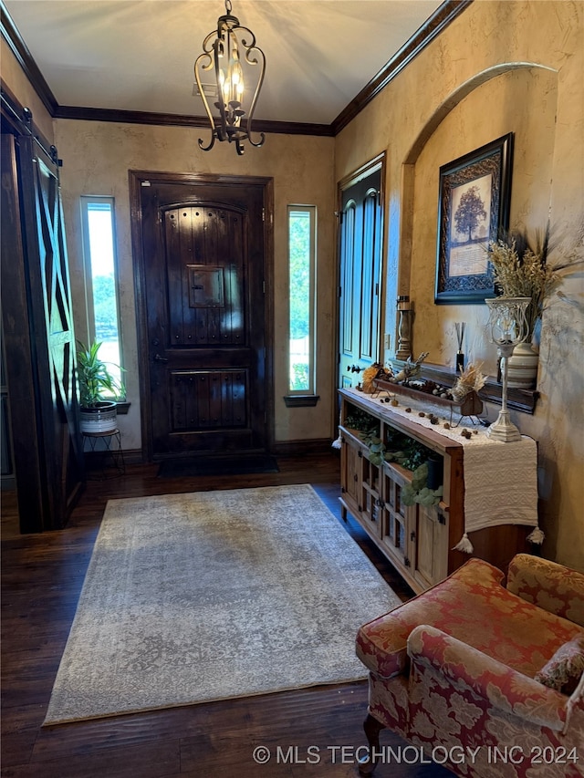 foyer featuring a chandelier, crown molding, plenty of natural light, and dark wood-type flooring