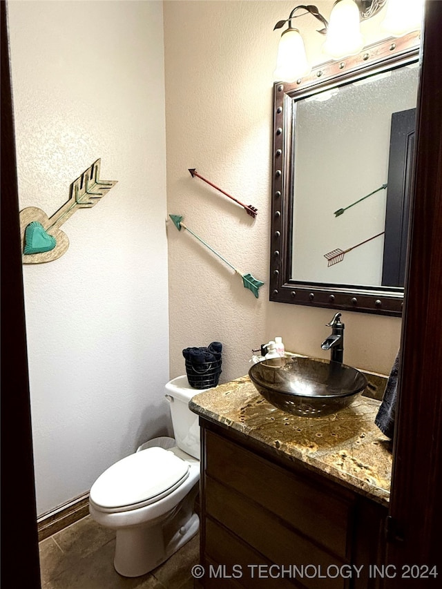 bathroom featuring tile patterned floors, vanity, and toilet