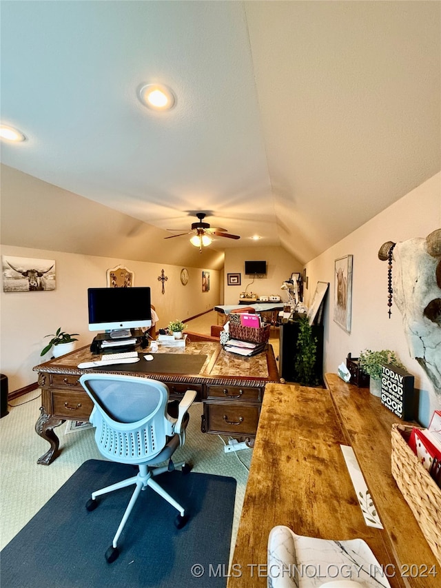 carpeted home office with ceiling fan and vaulted ceiling