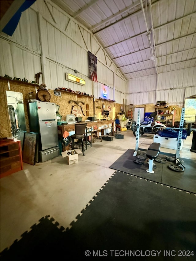 garage featuring stainless steel refrigerator and a workshop area