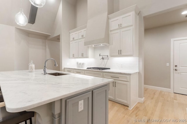 2708 W Van Buren Ct, Broken Arrow, OK 74134 - kitchen featuring custom exhaust hood, light wood-style flooring, light stone countertops, white cabinets, and lofted ceiling
