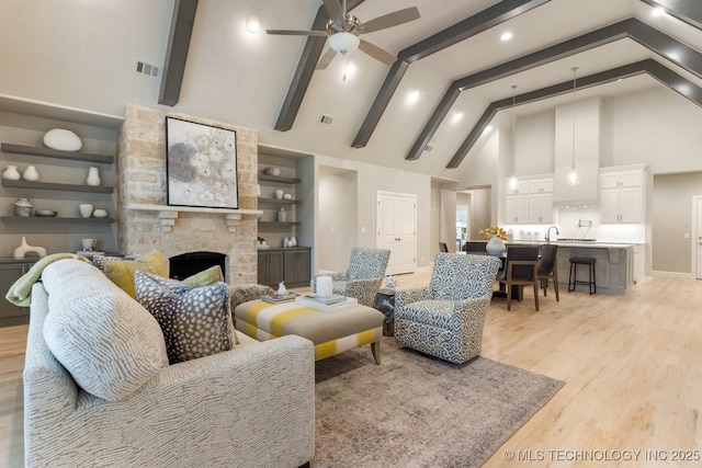 2708 W Van Buren Ct, Broken Arrow, OK 74134 - living room featuring high vaulted ceiling, a ceiling fan, a stone fireplace, light wood finished floors, and beam ceiling