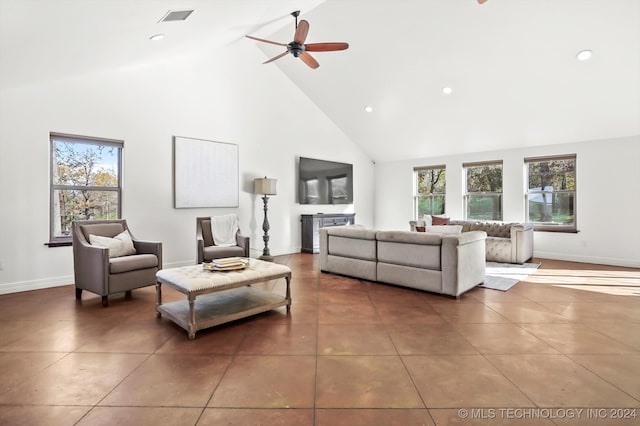 living room with dark tile patterned floors, high vaulted ceiling, ceiling fan, and a healthy amount of sunlight