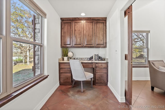 office space featuring light tile patterned floors and built in desk