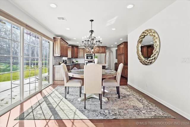 dining area with a notable chandelier and light hardwood / wood-style flooring